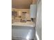 Kitchen with white cabinets, quartz counters, black appliances, and wood-look laminate flooring at 1150 Hillary Ln, Lawrenceville, GA 30043