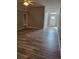 Open living room with hardwood flooring and modern lighting, leading to a bright entry at 1150 Hillary Ln, Lawrenceville, GA 30043