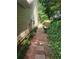 Narrow stepping stone path along the side of the house, surrounded by lush greenery and foliage at 1150 Hillary Ln, Lawrenceville, GA 30043