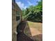 Side yard of a home featuring green grass, trimmed bushes, and mulch around the house foundation at 1150 Hillary Ln, Lawrenceville, GA 30043