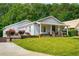 Well-kept one-story home with a cozy front porch, vibrant landscaping, and a driveway leading to ample parking at 1928 Main Nw St, Atlanta, GA 30318
