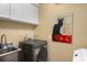 Functional laundry area with modern appliances, storage cabinets, and decorative cat poster at 1928 Main Nw St, Atlanta, GA 30318