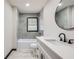 Well-lit bathroom features gray tiled walls, vanity and round mirror at 2091 Parker Ranch Se Rd, Atlanta, GA 30316