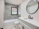 Modern bathroom features a tub and shower, vanity and round mirror at 2091 Parker Ranch Se Rd, Atlanta, GA 30316