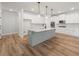 Bright kitchen with stainless appliances, large island, hardwood floor, and modern pendant lighting at 3301 Lions Ruby Ln, Atlanta, GA 30349