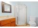 Bathroom features wood vanity, framed mirror, toilet, and glass corner shower at 557 Lawton Sw St, Atlanta, GA 30310