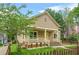 Quaint home with a covered front porch, inviting curb appeal, and a picket fence surrounding the property at 557 Lawton Sw St, Atlanta, GA 30310