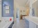 Spacious bathroom with blue accent wall, white countertops, tub, and vintage vanity at 690 Winding River Dr, Lawrenceville, GA 30046