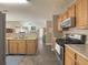 Spacious kitchen featuring wood cabinets, stainless steel appliances, and a view into the living area at 690 Winding River Dr, Lawrenceville, GA 30046