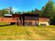 Charming home with a wooden porch and stairs, complemented by a lush green lawn and trees at 105 Doe Dr, Temple, GA 30179