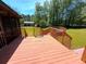 Exterior deck with wooden railings, providing outdoor space with a lush green lawn and trees at 105 Doe Dr, Temple, GA 30179