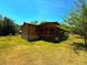 Quaint log cabin features a covered porch and is surrounded by a large, green lawn at 105 Doe Dr, Temple, GA 30179
