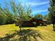 Charming log cabin with a covered front porch and lush green lawn at 105 Doe Dr, Temple, GA 30179