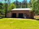 Outbuilding with two garage doors and ample space, surrounded by a green yard and natural light at 105 Doe Dr, Temple, GA 30179