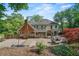 Spacious backyard featuring a patio with outdoor seating, mature trees, and manicured landscaping, perfect for outdoor gatherings at 1880 Redbourne Dr, Atlanta, GA 30350