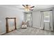 This carpeted bedroom boasts a ceiling fan, two windows, and a decorative floor mirror at 1880 Redbourne Dr, Atlanta, GA 30350