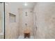 Modern shower with stylish tile, shower head and handheld sprayer, and a convenient wooden stool at 1880 Redbourne Dr, Atlanta, GA 30350