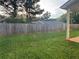 View of the backyard with a wooden fence and green grass, seen from the covered patio at 241 Coral Cir, Mcdonough, GA 30253