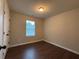 A bedroom features modern, dark laminate flooring and a single window with mini blinds at 241 Coral Cir, Mcdonough, GA 30253