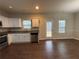 A spacious kitchen features stainless steel appliances, granite countertops, wooden floors, and white cabinets at 241 Coral Cir, Mcdonough, GA 30253