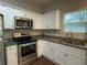 This modern kitchen has stainless appliances, granite counters, white cabinets, and hardwood floors at 241 Coral Cir, Mcdonough, GA 30253