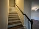 Staircase with dark stained wood handrail and treads with painted white risers at 241 Coral Cir, Mcdonough, GA 30253