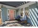 Cozy front porch with seating, a pink door, and elegant exterior lighting at 28 Peachtree Hills Ne Ave, Atlanta, GA 30305