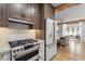 Eat-in kitchen featuring stainless appliances, gas range, custom cabinetry, and hardwood floors at 28 Peachtree Hills Ne Ave, Atlanta, GA 30305
