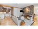 Open-concept living room featuring hardwood floors, a stone fireplace, and a view into the kitchen at 28 Peachtree Hills Ne Ave, Atlanta, GA 30305