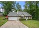 Traditional home featuring a two-car garage, well-manicured lawn, and shuttered windows at 4934 Woodstream Nw Ln, Acworth, GA 30102