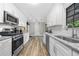 Bright kitchen features white cabinets, granite counters, stainless steel appliances, and modern subway tile backsplash at 4934 Woodstream Nw Ln, Acworth, GA 30102