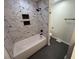 The bathroom features a marble tile shower/tub combo with black plumbing fixtures at 600 Mary Erna Dr, Fairburn, GA 30213