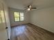 Bright bedroom featuring modern laminate floors, neutral paint, fresh trim, and large window at 600 Mary Erna Dr, Fairburn, GA 30213