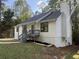 Charming home featuring fresh white siding, dark roof, blue front door, and well-maintained landscaping at 600 Mary Erna Dr, Fairburn, GA 30213