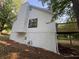 Exterior shot of a home with white siding, dark framed windows, chimney, and an elevated deck at 600 Mary Erna Dr, Fairburn, GA 30213