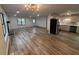 Open living space featuring wood-look floors, fireplace, an open layout to the kitchen, and modern lighting at 600 Mary Erna Dr, Fairburn, GA 30213