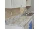 Close-up on kitchen marble countertops with a chrome faucet and a tiled backsplash at 6354 Shannon Pkwy # 20D, Union City, GA 30291