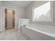 Bright bathroom with a soaking tub, large window, and sliding door to closet at 6861 Ga Hwy 5, Douglasville, GA 30135
