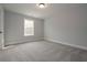 Neutral bedroom featuring soft carpet, a large window, and light gray walls at 6861 Ga Hwy 5, Douglasville, GA 30135