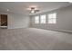 A bonus room featuring neutral decor, carpet, and bright, natural light from large windows and a ceiling fan at 6861 Ga Hwy 5, Douglasville, GA 30135