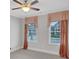 Cozy bedroom featuring two windows with curtains, neutral walls, and a ceiling fan at 3538 Serenade Nw Commons, Kennesaw, GA 30152