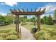 Inviting entrance to a private community area featuring a pergola, walking path, and lush landscaping at 3538 Serenade Nw Commons, Kennesaw, GA 30152