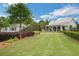 Beautifully landscaped backyard featuring a well-manicured lawn and a charming white farmhouse-style house at 3538 Serenade Nw Commons, Kennesaw, GA 30152