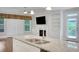Kitchen island with stainless sink overlooks the living area with fireplace and backyard access at 3538 Serenade Nw Commons, Kennesaw, GA 30152