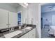 Bathroom featuring a double sink with a granite countertop, white cabinets, and doorways at 401 Night Hawk Ct, Canton, GA 30114