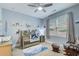 Well-lit Bedroom with ceiling fan, crib, dresser, rocking chair, and natural-themed decor at 401 Night Hawk Ct, Canton, GA 30114