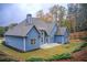 Exterior view of a blue two-story home with a grey roof and manicured landscaping at 401 Night Hawk Ct, Canton, GA 30114