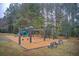 Community playground featuring swings and slides with bench seating in a wooded area at 401 Night Hawk Ct, Canton, GA 30114