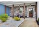 Charming front porch with stone columns, rocking chairs, and a wood-stained front door at 401 Night Hawk Ct, Canton, GA 30114