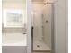 Bright bathroom featuring a tub and shower with tiled walls and a window at 4940 Elm Brook Dr, Atlanta, GA 30349